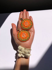 Handmade Embroidered Circular Earrings With Orange And Green Thread
