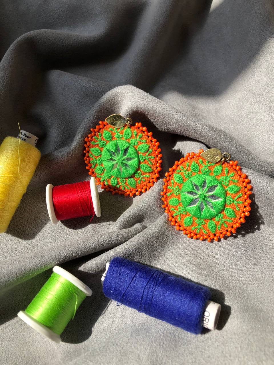 Handmade Embroidered Circular Earrings With Greean And Orange Thread