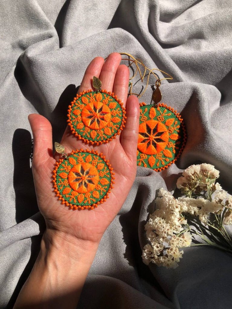 Handmade Embroidered Circular Earrings With Orange And Green Thread