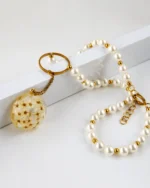 Elegant handmade pearl necklace with golden details and a round resin pendant containing real dried white flowers, displayed on a white background