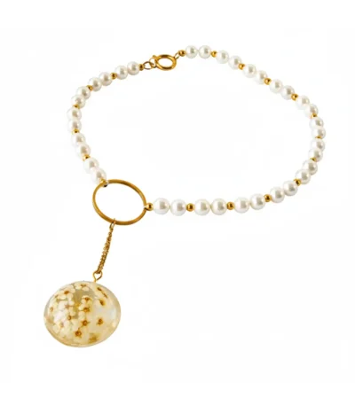 A pearl choker necklace featuring white beads and gold accents, with a round resin pendant containing delicate preserved white flowers