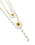 A delicate gold-chain necklace featuring two real pressed daisy flowers, accented with small white pearls and a dangling teardrop pearl, displayed on a white background