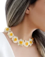 Handmade choker necklace with real narcissus flowers preserved in UV resin, worn by model with long hair, nature-inspired jewelry design