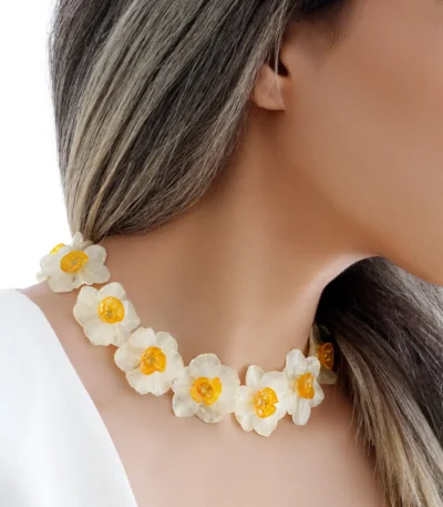 Handmade choker necklace with real narcissus flowers preserved in UV resin, worn by model with long hair, nature-inspired jewelry design