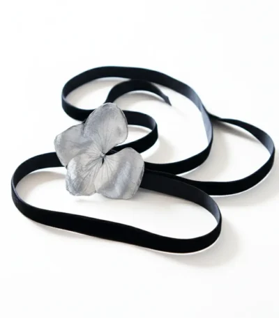 A black velvet choker featuring a silver hydrangea flower centerpiece, displayed on a white background.