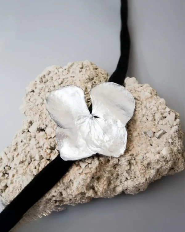 Handmade choker featuring a real hydrangea flower coated with silver leaf and UV resin, set on a black velvet band
