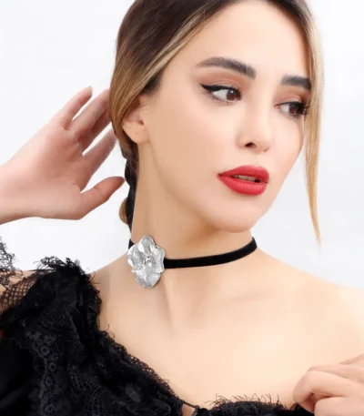 Model wearing a handmade choker necklace with a real hydrangea flower coated in silver leaf and UV resin, set on a black velvet band