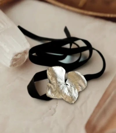 Handmade choker featuring a real hydrangea flower coated with silver leaf and UV resin, set on a black velvet band