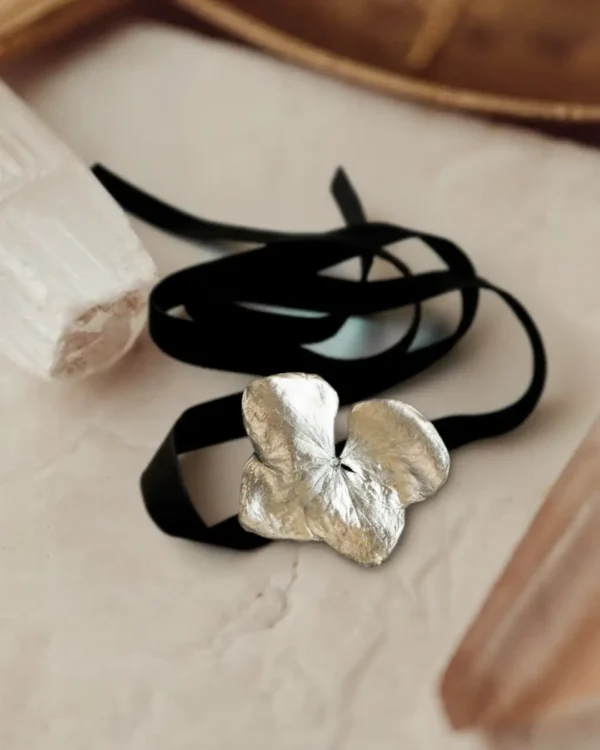 Handmade choker featuring a real hydrangea flower coated with silver leaf and UV resin, set on a black velvet band