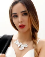 Model wearing a handcrafted statement necklace featuring multiple real hydrangea petals coated in silver leaf and UV resin, set on a delicate silver chain