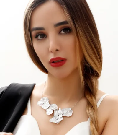 Model wearing a handcrafted statement necklace featuring multiple real hydrangea petals coated in silver leaf and UV resin, set on a delicate silver chain
