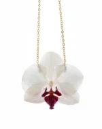 A delicate white orchid flower preserved in clear resin, hanging from a fine gold chain against a clean white background.