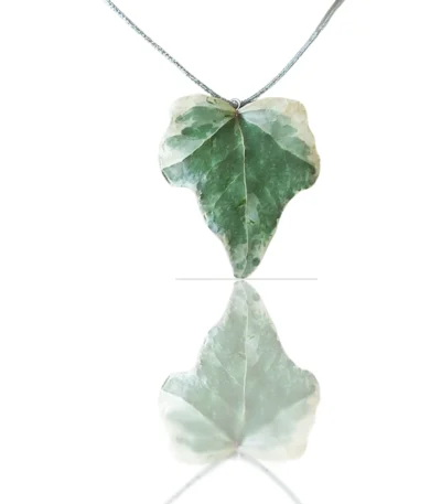Handmade ivy leaf necklace with silver lame cord and stainless steel clasp on neutral background