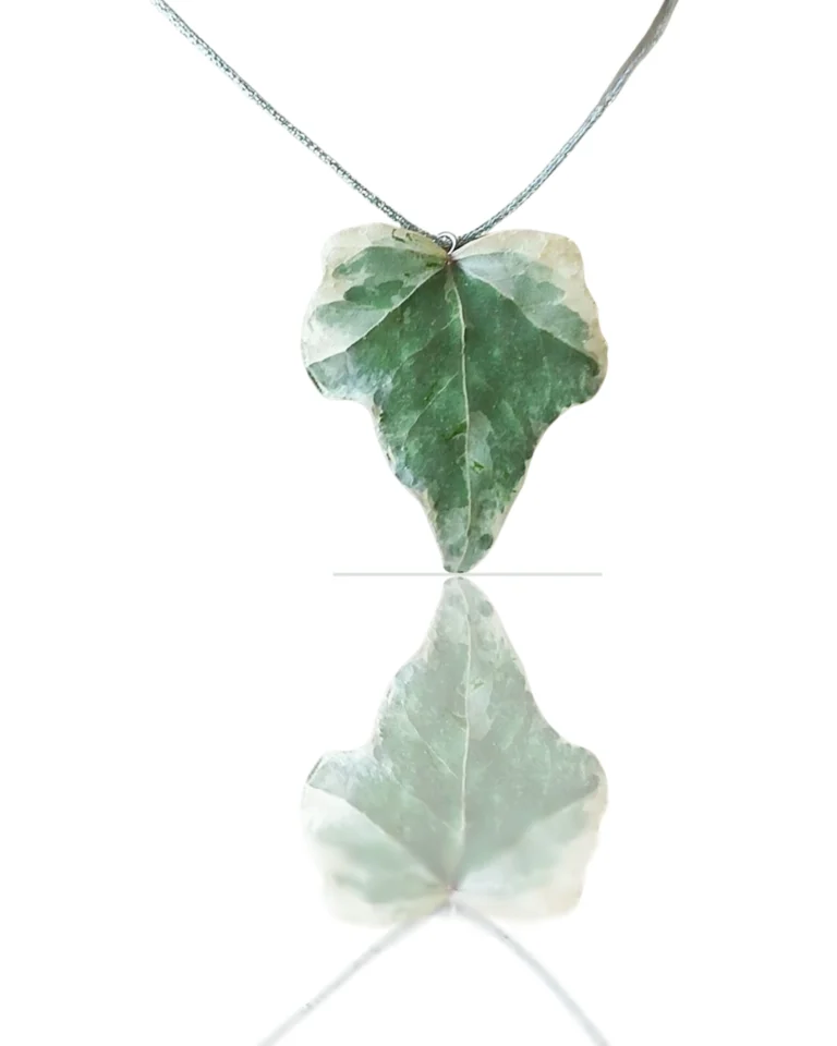 Handmade ivy leaf necklace with silver lame cord and stainless steel clasp on neutral background