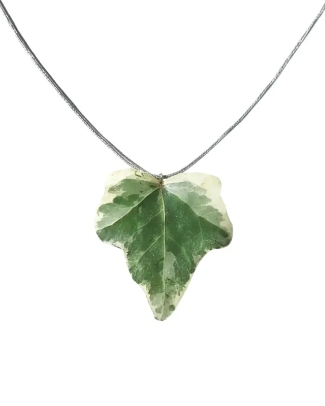 Handmade ivy leaf necklace with silver lame cord and stainless steel clasp on neutral background